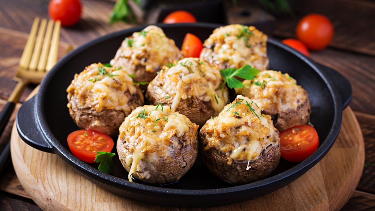 Baked mushrooms stuffed with chicken minced meat, cheese and herbs on a wooden background