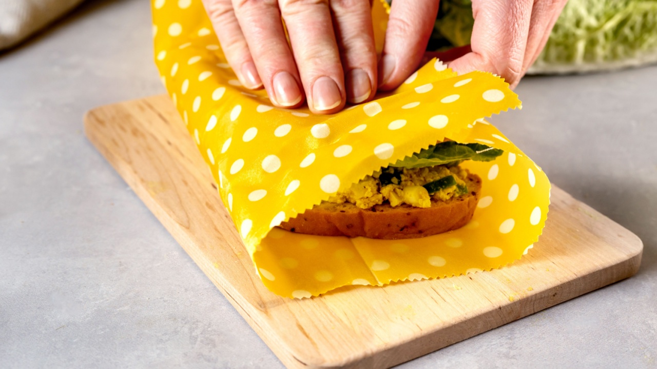 Woman hands wrapping a healthy sandwich in beeswax food wrap and cotton bag