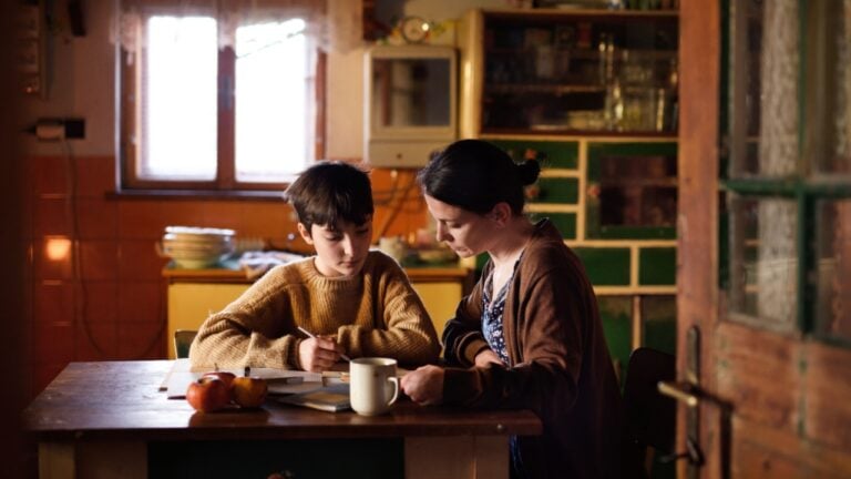 Poor mature mother and small daughter learning indoors at home, poverty concept.