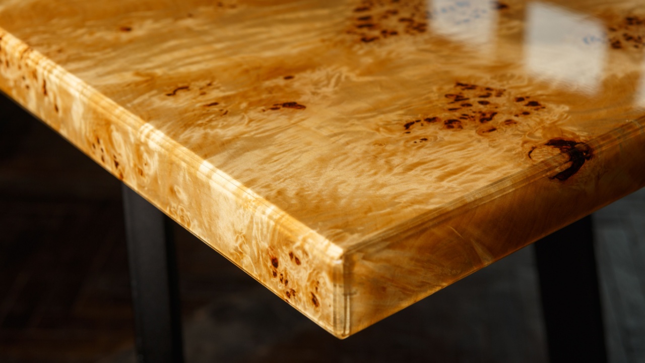 Table top for a table made of poplar burl wood and transparent epoxy resin. The resin is varnished and polished, the wood is saturated with tung oil.