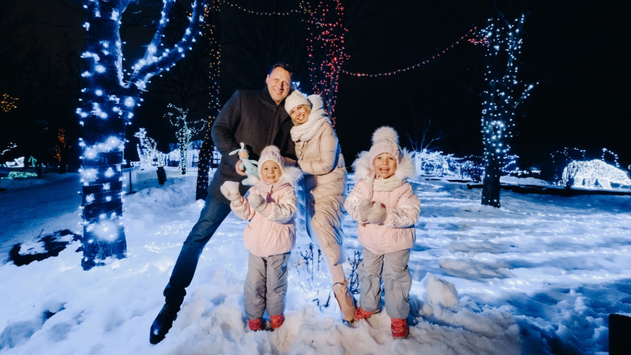 A large family with children in a Christmas city at night with night lights.