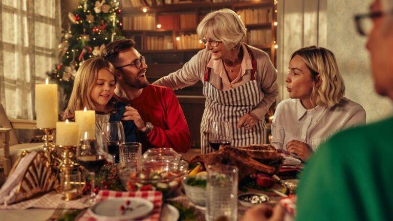 Happy multi-generation family talking while having New Year's meal at dining table.