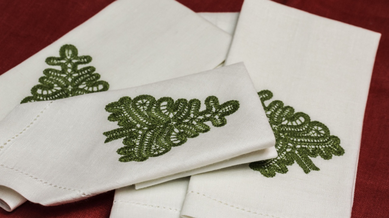Linen napkins with embroidery in the shape of a Christmas tree and hemstitch along the edges for a family feast.