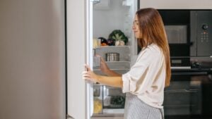 Young woman taking food from the fridge