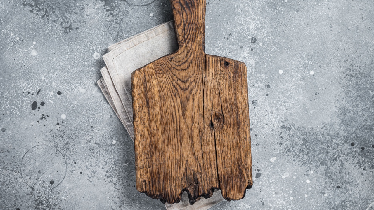 Cooking background with old empty cutting board over the towel. Gray background. Top view. Copy space