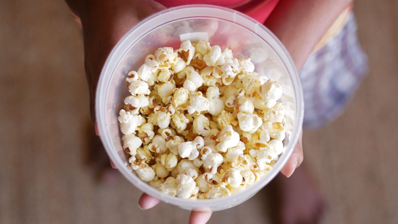 young man eating popcorn close up