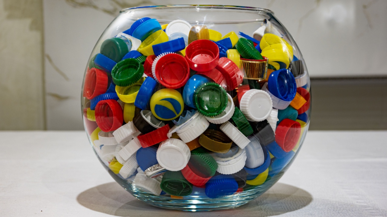 a lot of plastic bottle caps, healthy food concept, unhealthy food. plastic lids on the table, lids in a bowl.