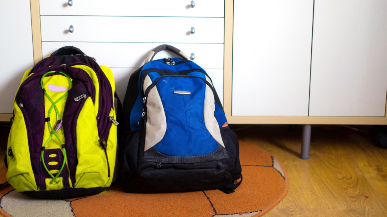 Two travel backpacks are on the floor. Refugees' belongings