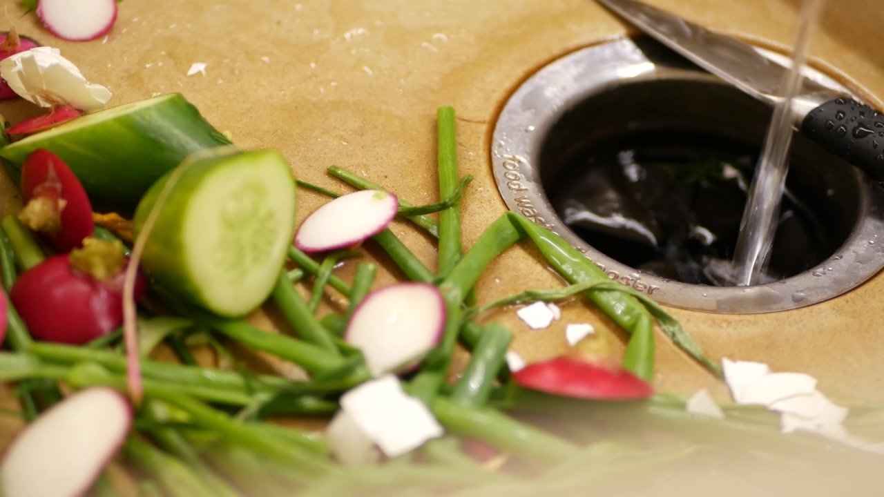 Organic garbage in sink with built-in food waste disposer. vegetable or fruits peels, remains and leftovers and disposal grinder. Zero waste, sustainable development and garbage separation concept.