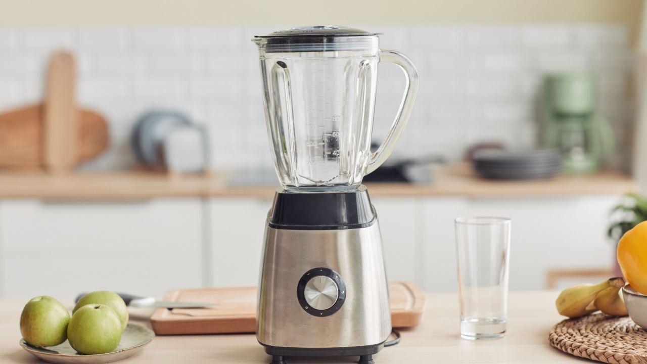 Background image of chrome blender on kitchen counter with fruits, copy space