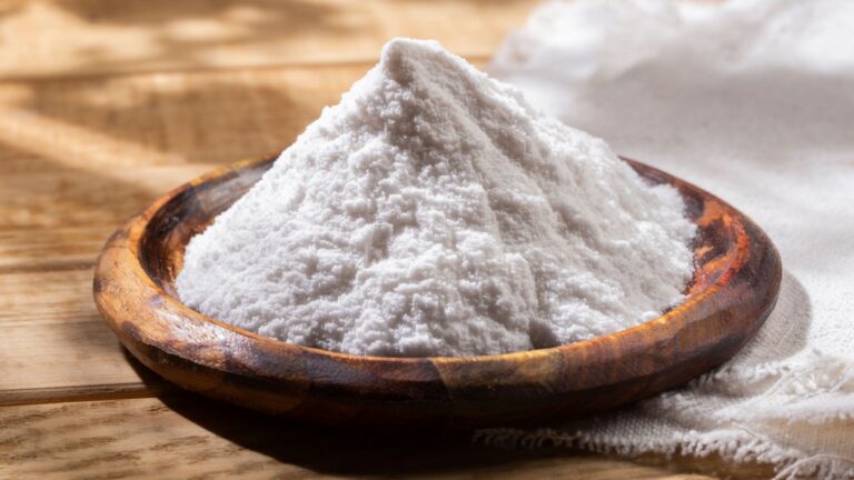 Baking soda in wooden bowl on the table.
