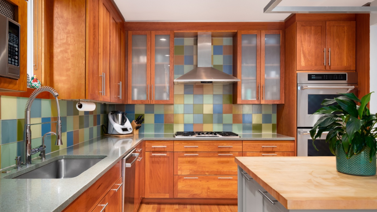 ELMHURST, IL, USA - MAY 1, 2022: A kitchen with wood cabinets, stainless steel appliances, and colorful square tile backsplash.