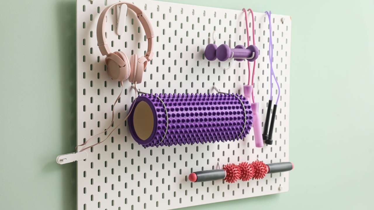 Pegboard with sports equipment and headphones on green wall