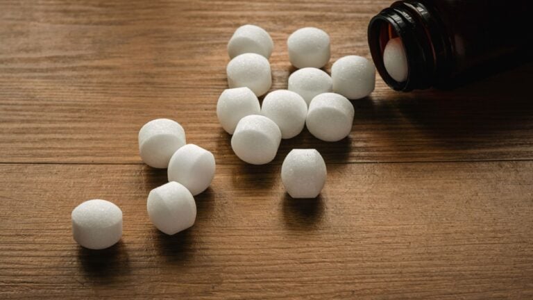Naphthalene mothballs on wooden background.