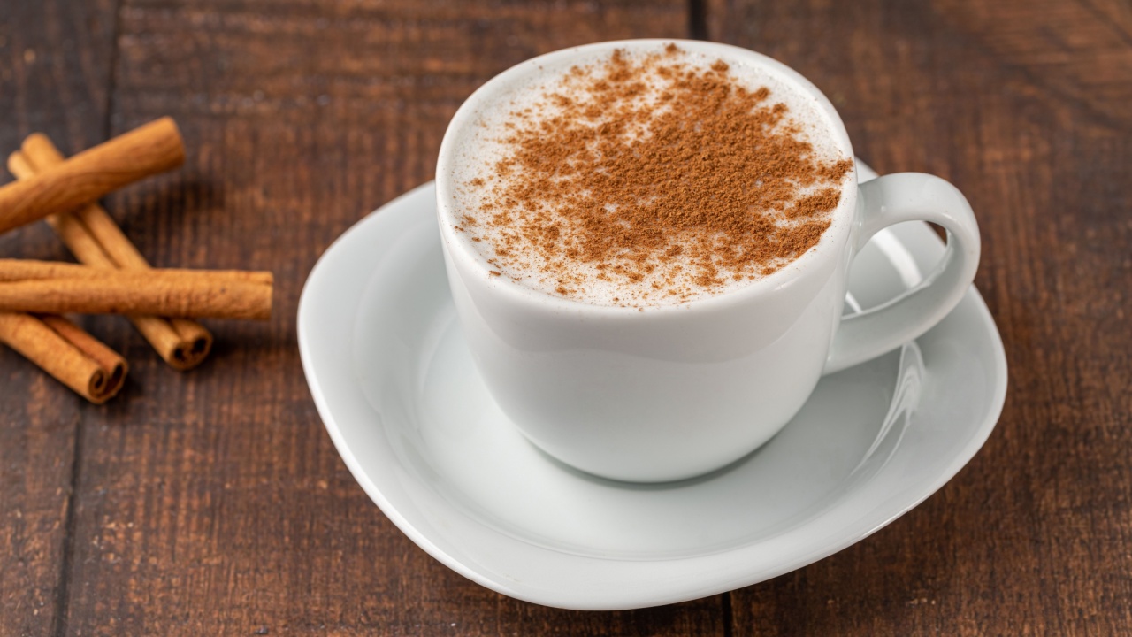 Cinnamon sprinkled salep in a white cup on wooden table