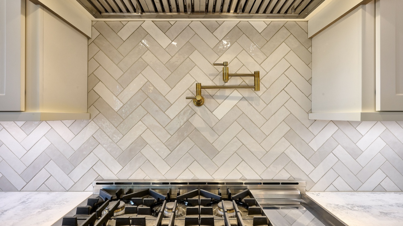 Pot filler on kitchen backsplash above gas range burners