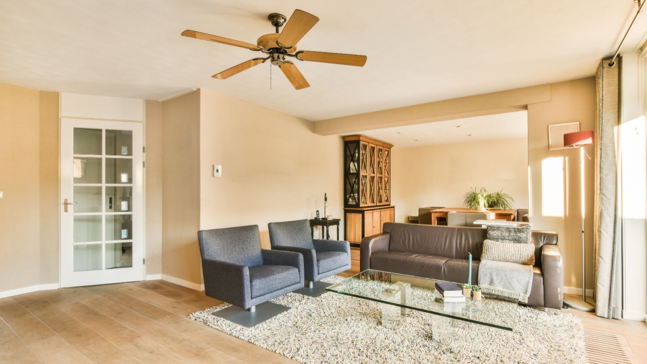 a living room with two couches and a ceiling fan in the room is very light brown, but it's not too