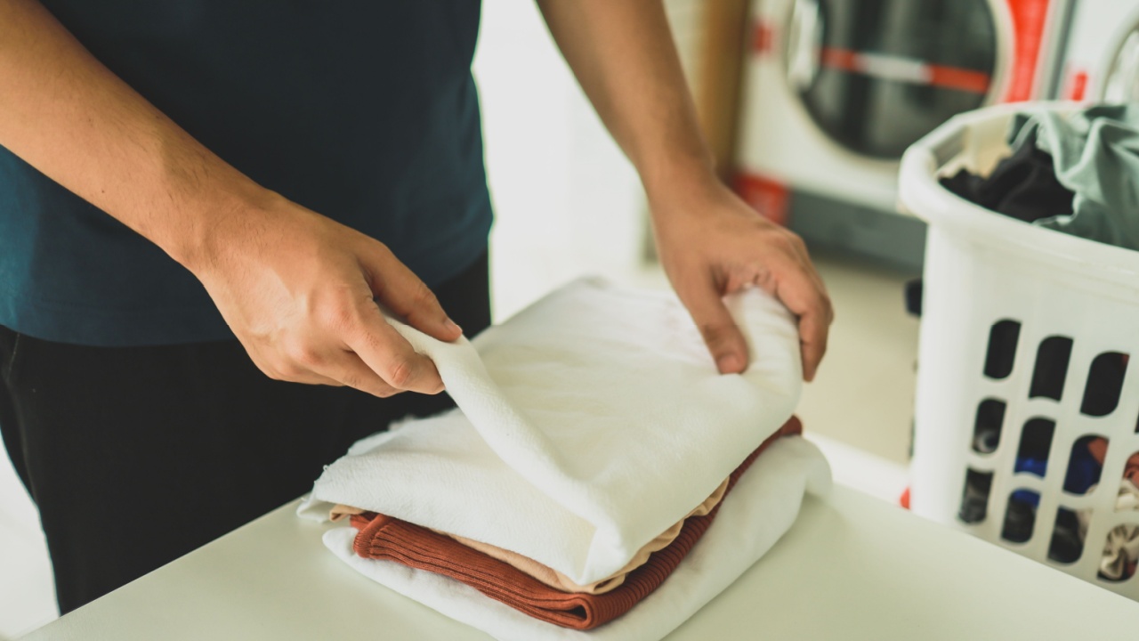 House husband with Basket and dirty laundry washed clothing in laundry room interior. washing machine at laundry business store concept