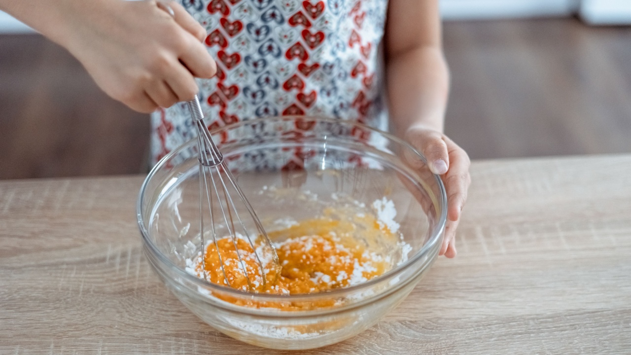 Wire whisk and eggs. whipped egg yolks with sugar in a glass bowl