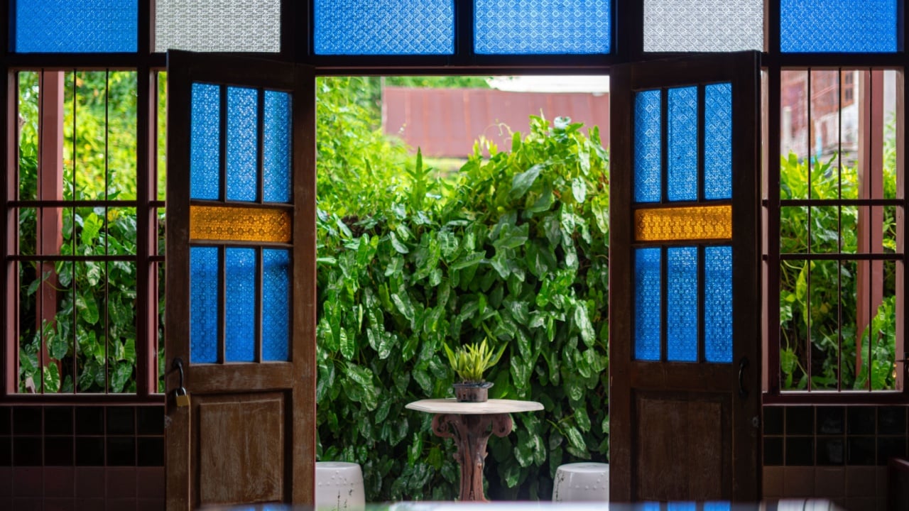 Stained glass of various colors is used to embellish the walls, doors, and windows of the old wooden house