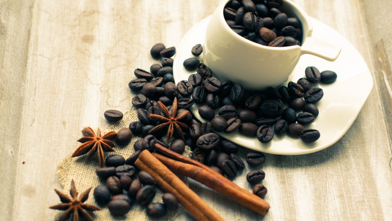 Cup of coffee, cinnamon and anise stars on the wooden table