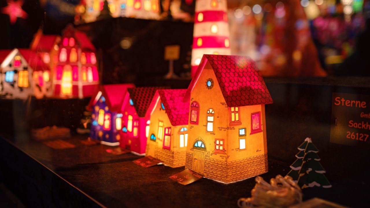 Essen, Germany - December 13, 2022: Christmas atmosphere at the open xmas market. Celebrating Xmas holidays. Lights, carousel, small houses, toys and decorations at fair in European city or town