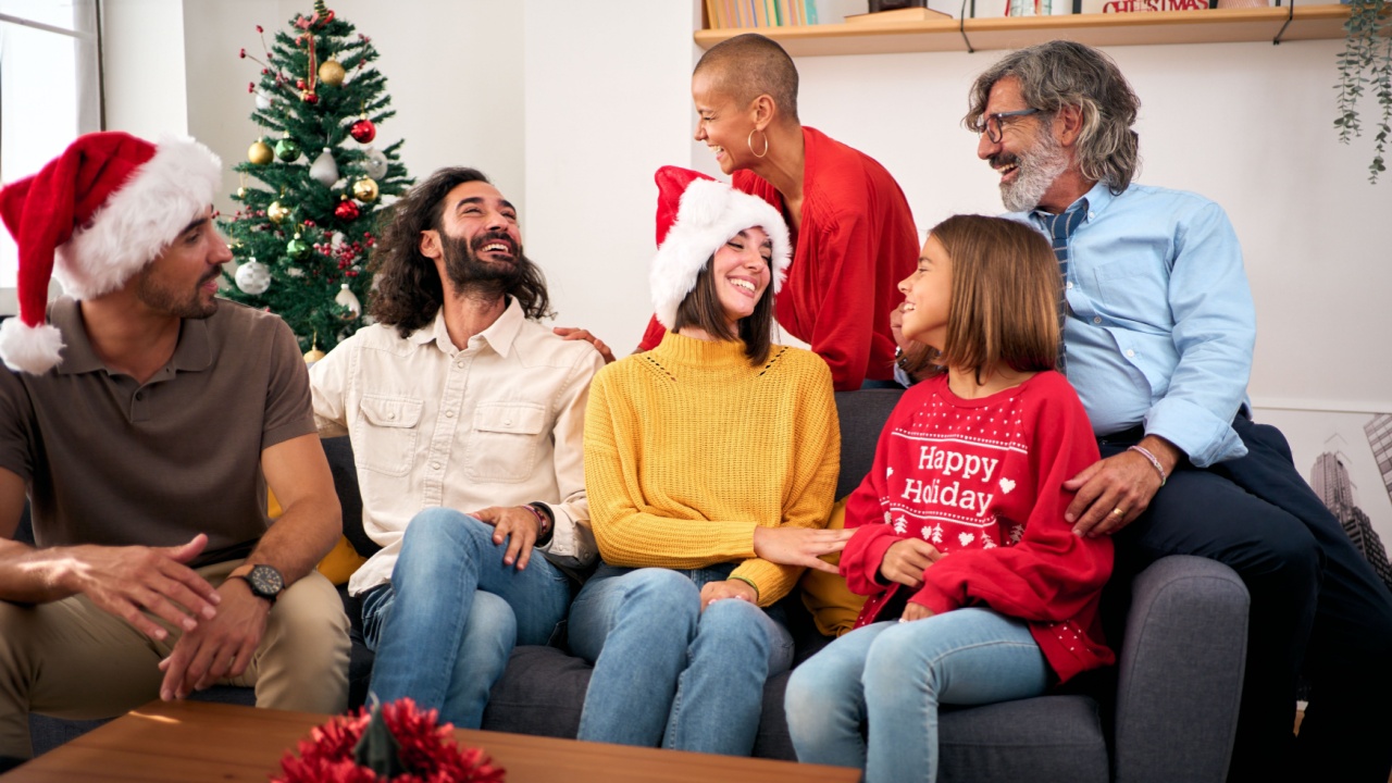 Indoor portrait of caucasian multi generation family gathered at living room celebrating christmas together home interior. Happy people smiling with a positive expression enjoying the winter holidays