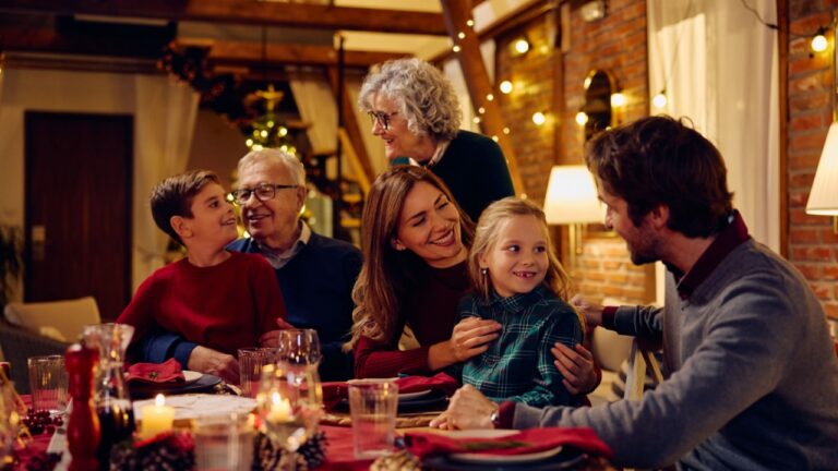 Happy extended family talking during Christmas dinner at dining table.