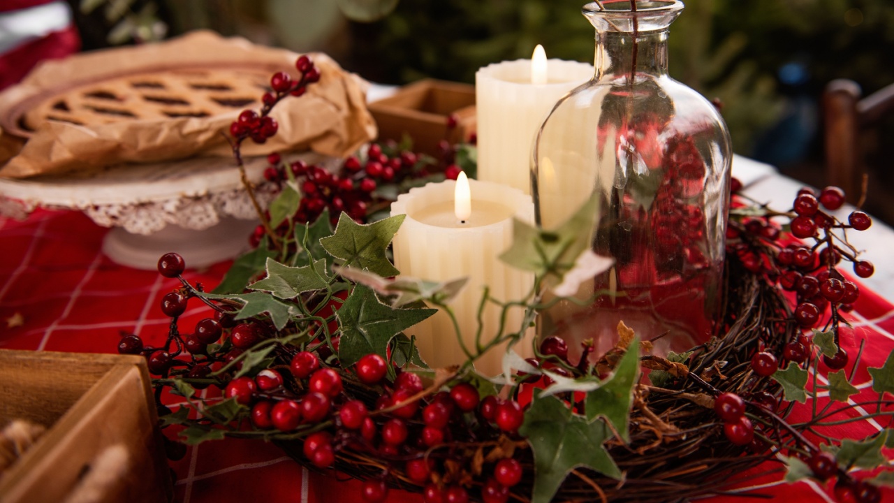 Christmas holiday table with open cranberry, cherry pie on red tablecloth with candles, advent wreath, apples. Flat lay is decorated with green spruce branches, berries of holly, eucalyptus. Homemade