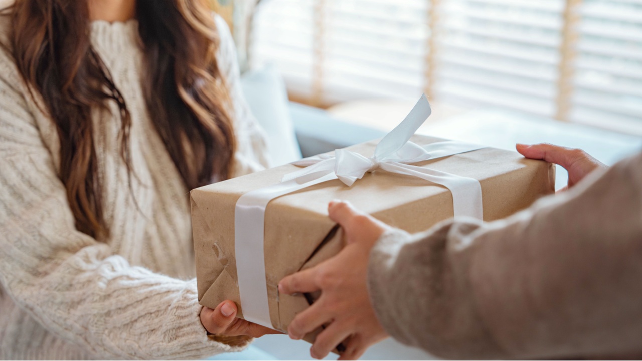 Excited asian woman getting surprise gift from her girlfriend at home. Gives a gift, birthday gift, New year day celebration and congratulation