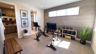 Denver, Colorado, USA-March 3, 2024-This spacious home gym boasts a clean, modern design with elegant wood paneling and large windows allowing natural light to flood the space, enhancing the workout