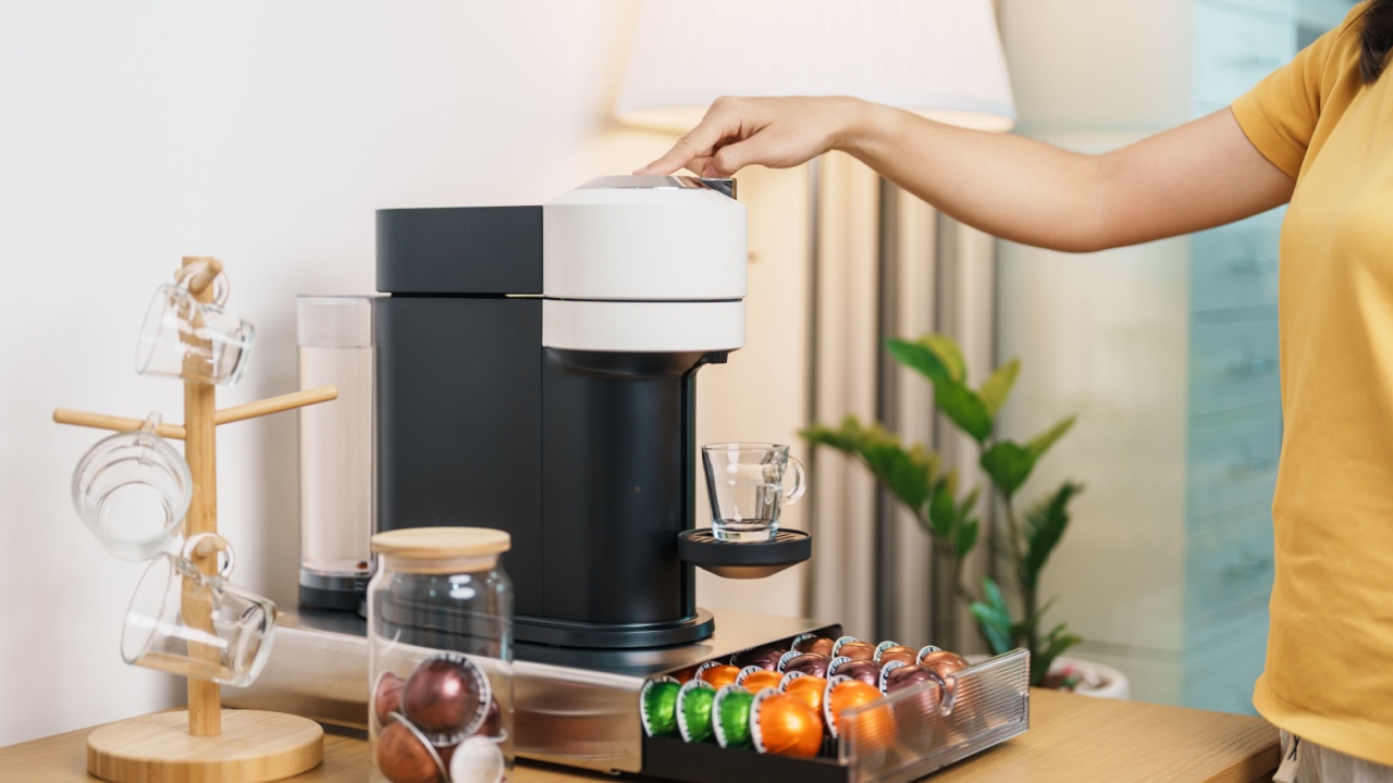 hand making Espresso Coffee by Coffee Maker Machine with Capsule of roasted coffee bean on wood table bar. Daily beverage drink at Home, coffee pods
