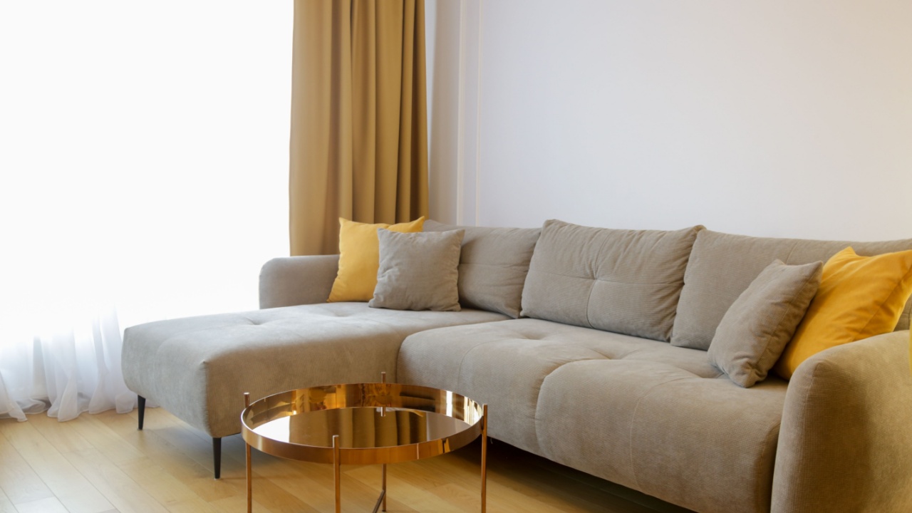 Modern cozy apartment with a touch of yellow, living room with sofa and dining table,