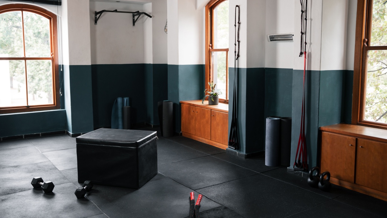 Empty gym with black hardwood flooring and ottoman
