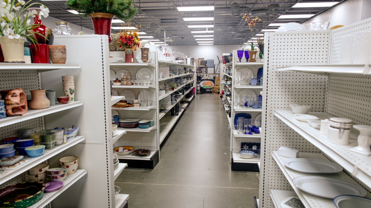 Second hand used goods displayed on shelves at a thrift store. Thrifting concept, buying used things.