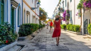 A woman walking in the port of the coastal town Mogan in the south of Gran Canaria. Spain