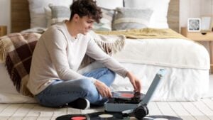 Young man with record player in bedroom