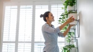 Woman taking care of the plants at her apartment