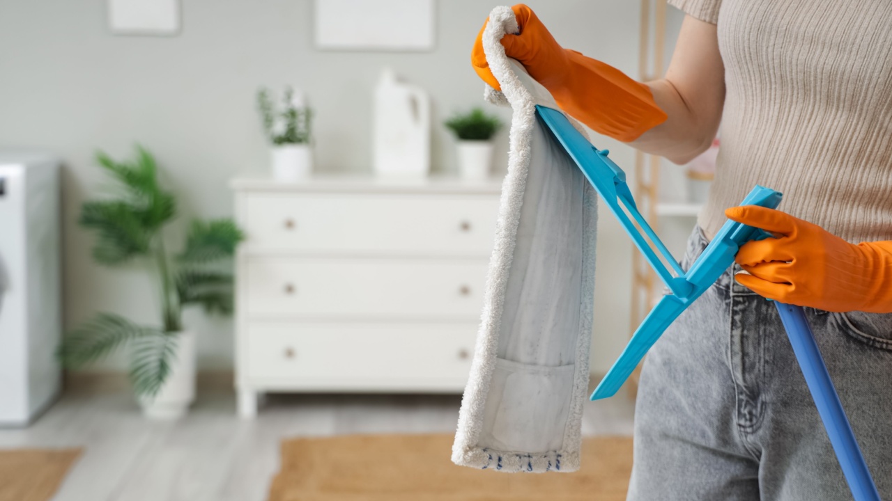 Woman taking mop head off in laundry room, closeup