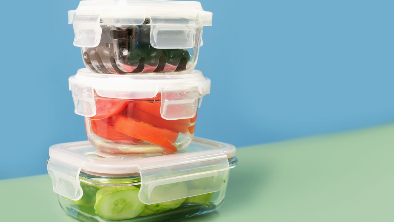 Glass boxes with sliced vegetables on blue and green background front view.