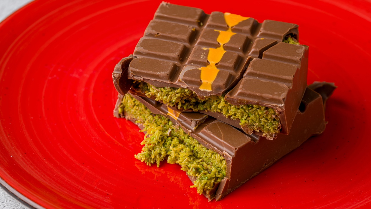Dubai Chocolate bar with green kadayif and peanut butter on white stone table