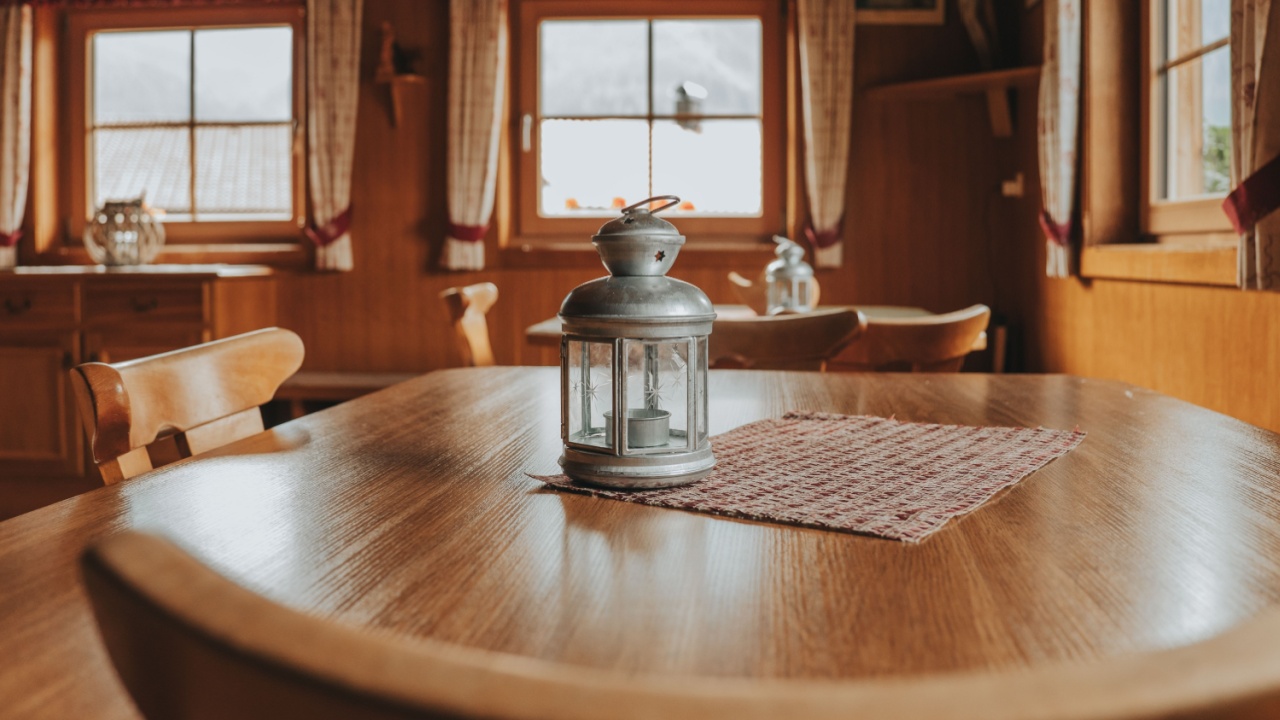 Table lamp on wooden table in cozy chalet background.Metallic Home Decor. Austrian Chalet Interior. Wooden house interior.Cozy warm room with wooden furniture.Table lamp silver metal