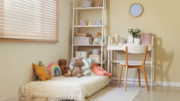 Interior of cozy children's room with shelving unit, workplace and many toys on bed