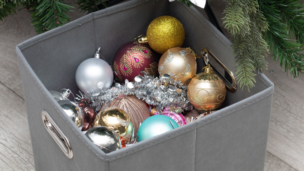 a box of Christmas decorations near a decorated Christmas tree.