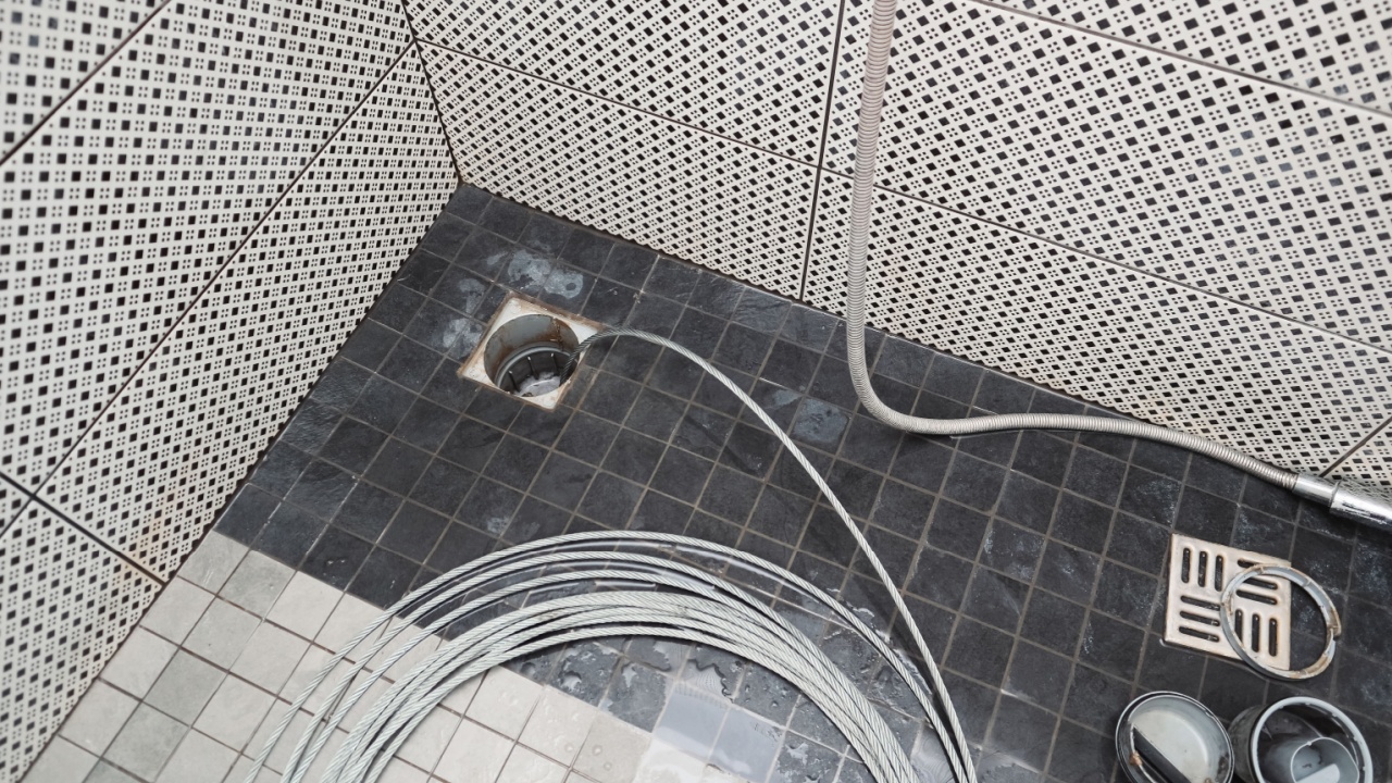 Sewer cleaning. Cleaning the sewer with a cable. Plumber using a drain snake to unclog the shower. Plumbers extracting snake tool.