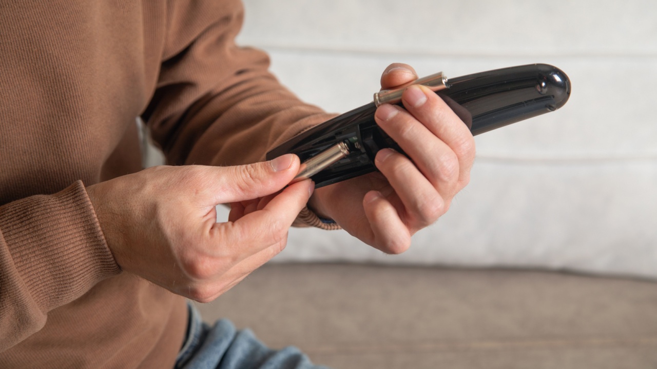 Man installs a new battery in the remote control of a TV