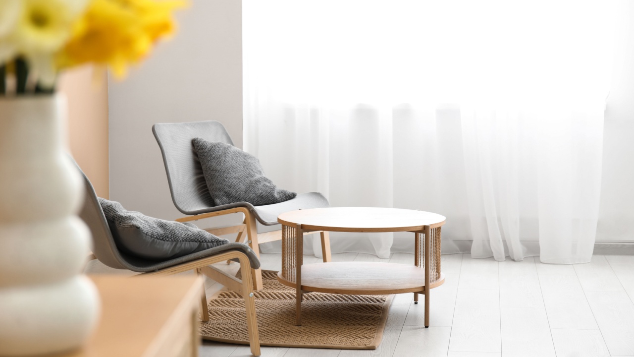Chairs and coffee table near light curtain in room