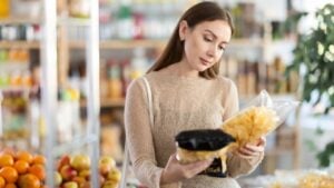 Female shopper chooses chips while shopping at a supermarket