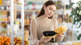 Female shopper chooses chips while shopping at a supermarket