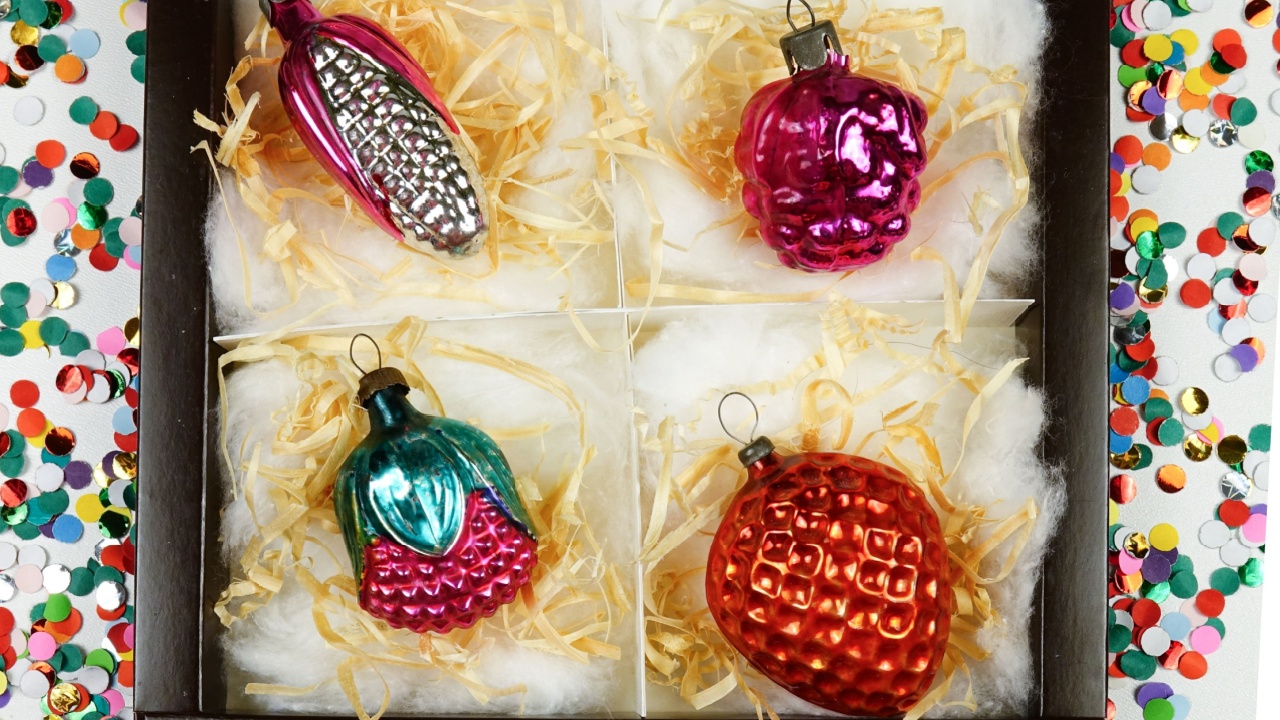 Box with collection of vintage glass Christmas decorations stand on a white board, top view, storing things in the house